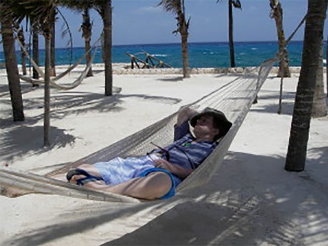 A guy relaxing in a hammock on a beach