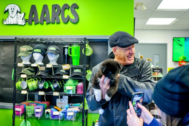 Bob Reader holding puppy at Alberta Animal Rescue Crew Society